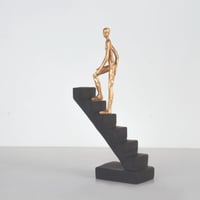 مجسم لشخص يتحرك لأعلى السلم