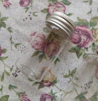 قارورة زجاج صغيرة بغطاء فضي