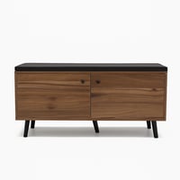 مقعد خشبي أنيق بوسادة سوداء ودواليب تخزين عملية.