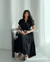 فستان أسود ناعم بكسرات جانبية وحزام أنيق