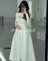 فستان أبيض أنيق بقصة ناعمة وتصميم ساتر