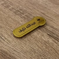 بروش اسم ذهبي معدن مغناطيس ( عرض 7سم ارتفاع 2.3 )