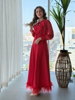 فستان بتفاصيل ناعمة وربطة عنق جذابة وريش يزيّن الأ...