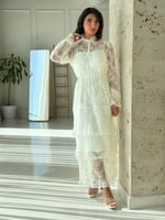 فستان دانتيل أبيض أنيق بتفاصيل شفافة وقصة عصرية