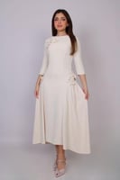 فستان أنيق بلون كريمي ناعم، بتصميم راقٍ يبرز الأنو...