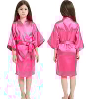 روب أطفال من الساتان. يتميز بأكمام واسعة وحزام مطا...