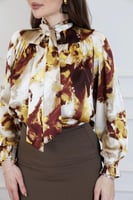 بلوزة بطبعة فنية غنية بالألوان الدافئة