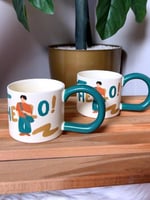 طقم أكواب سيراميك برسمة “Hello!” بيد فنية ملونة –...