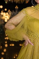 فستان سهرة أصفر بتصميم ملكي وتفاصيل لؤلؤية فاخرة