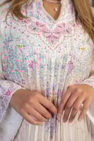 جلابية ناعمة بثنيات طولية ونقوش زهرية هادئة