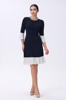 فستان أسود بأطراف بيضاء وياقة مرصعة بالأحجار