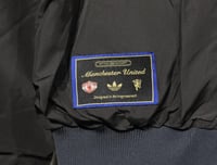 جاكيت مانشستر يونايتد وجهين 2025-2026 اسود و ازرق