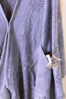 رداء بقبعة مع جيوب وبروش أنيق وعملي.