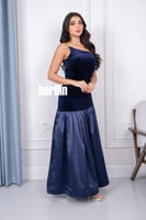 فستان مخمل يتميز بقصة مائلة في الصدر وبقصة كلوش لو...