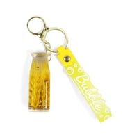 تعليقة شنط بشكل قارورة باللون الأصفر