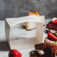 علب كيك شفافة بإطار أبيض بمسكه