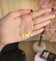 عقد يجمع-حرفين في بريق الذهب عيار 21.