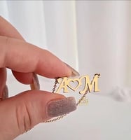 عقد يجمع-حرفين في بريق الذهب عيار 21.