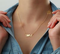 عقد يجمع-حرفين في بريق الذهب عيار 21.