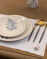 مفرش لينن ابيض بتطريز ورد بالاسفل مع جوانب مطرزة