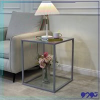 طاولة جانبية بلون فضي وبسطح زجاجي شفاف
