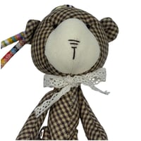 دمية دب قماشية مزخرفة بربطة عنق دانتيل