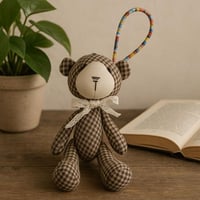 دمية دب قماشية مزخرفة بربطة عنق دانتيل