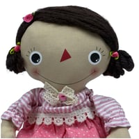 دمية قماشية بفستان وردي ومفتاح ذهبي