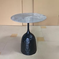 طاولة قهوة دائرية بسطح رخامي وقاعدة سوداء مميزة