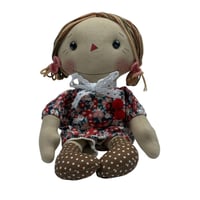 دمية قماشية بملابس مزهرة