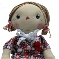 دمية قماشية بملابس مزهرة