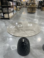طاولة قهوة دائرية بسطح رخامي وقاعدة سوداء مميزة