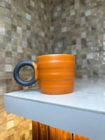 كوب سيراميك برتقالي بمسكه سوداء