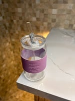 كوب زجاجي مع مصاص لون وردي