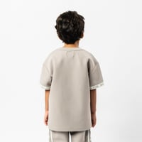 تي شيرت رمادي كبير للأطفال برقبة دائرية وشعار مطبو...