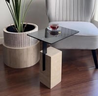 طاولة خدمة جانبية بقاعدة حجرية مستطيلة وسطح زجاجي