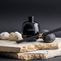 فواحة عطر بالأعواد في حامل زجاجي برائحة العنبر