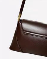 شنطة كتف جلد باللون البني الداكن بتفاصيل ذهبية أني...