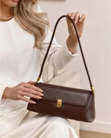 شنطة كتف جلد باللون البني الداكن بتفاصيل ذهبية أني...