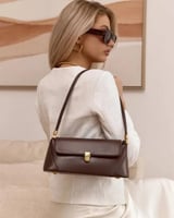 شنطة كتف جلد باللون البني الداكن بتفاصيل ذهبية أني...