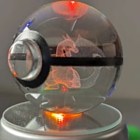 كورة بوكيمون زجاجية مع قاعدة مضيئة.