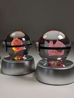 كورة بوكيمون زجاجية مع قاعدة مضيئة.