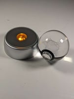 كورة بوكيمون زجاجية مع قاعدة مضيئة.