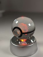 كورة بوكيمون زجاجية مع قاعدة مضيئة.