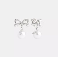 أقراط كوتش على شكل فيونكه من اللؤلؤ