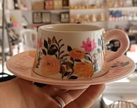 مق زهور أنيق مع صحن وردي لتقديم القهوة واللاتيه