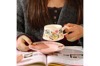 مق زهور أنيق مع صحن وردي لتقديم القهوة واللاتيه