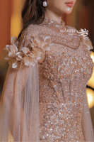 فستان سهرة فاخر بترتر ذهبي وأكمام شفافة مزينة بالو...