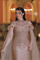 فستان سهرة فاخر بترتر ذهبي وأكمام شفافة مزينة بالو...