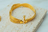 اسوارة مع خاتم ذهب بتصميم الاوميقاء عيار 21